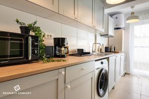 a kitchen with a microwave and a washer and dryer at New Residence Concept Studio in Roşu