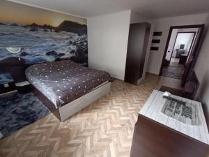Un dormitorio con una cama y una mesa. en Vila Adelina en Buşteni