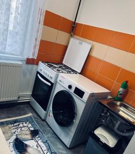 a kitchen with a washing machine and a microwave at Luana & Priam home in Petrila +1 photo