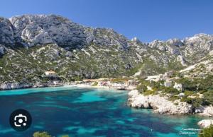 a view of a beach with blue water and mountains at Les Terrasses des Calanques in Marseille