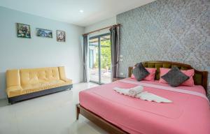 Un dormitorio con una cama rosa con un animal de peluche. en Villa loved beach AO NAM MAO 1 en Ao Nam Mao