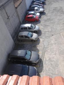 een rij auto's geparkeerd op een parkeerplaats bij San Antonio Inn in Quito