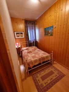 Dormitorio pequeño con cama y alfombra en Appartamento a Monclassico, en Monclassico