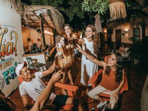 un groupe de personnes tenant des boissons dans un bar dans l'établissement Viajero Cartagena Hostel, à Carthagène des Indes