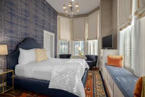 a bedroom with a bed and a tv and windows at Hamilton Turner Inn in Savannah