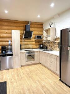 a kitchen with wooden walls and stainless steel appliances at Guest House in Synevyrsʼka Polyana
