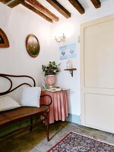 um quarto com um banco e uma mesa com um vaso na parede em Appartamento elegante em Morciano di Romagna