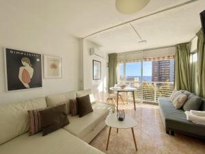 een woonkamer met een bank en een groot raam bij Caballos Levante Beach in Benidorm