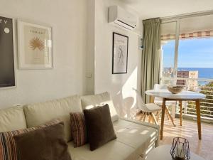 uma sala de estar com um sofá e uma mesa em Caballos Levante Beach em Benidorm