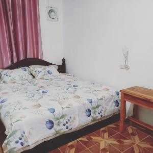 a bedroom with a bed with blue flowers on it at watthat & Maladress GUESTHOUSE in Luang Prabang