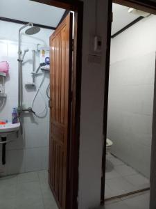 a bathroom with a shower and a toilet and a door at watthat & Maladress GUESTHOUSE in Luang Prabang