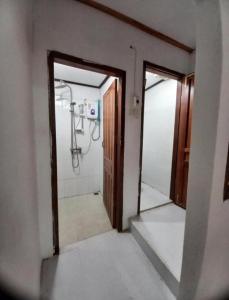 an open door to a bathroom with a shower at watthat & Maladress GUESTHOUSE in Luang Prabang