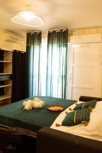 een slaapkamer met een groot bed met groene lakens bij Cosy Studio Coeur de l'Océan vue mer et aéroport in Saint-Denis