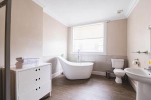 łazienka z wanną, toaletą i umywalką w obiekcie Tullie Inn w mieście Balloch
