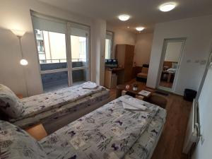 a hotel room with two beds and a window at Gabrovo Relax Apartment in Gabrovo