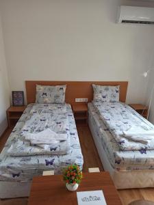 two twin beds in a room with a table at Gabrovo Relax Apartment in Gabrovo