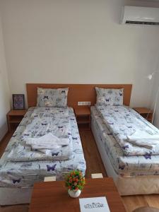 two twin beds in a room with a table at Gabrovo Relax Apartment in Gabrovo +20 photos