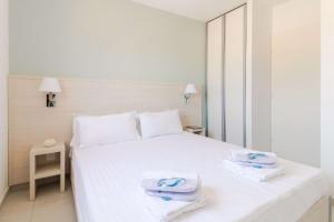 - une chambre avec un lit blanc et des serviettes dans l'établissement SELECT'SO HOME - Résidence Le Poséidon - Mazet en Duplex - Prestations de qualité & Services Hôteliers - POS-G, à Bormes-les-Mimosas