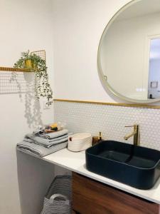 een badkamer met een blauwe wastafel en een spiegel bij LE GARENGEOT 2 -WIFi-CENTRE VILLE in Vitré