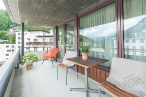 a balcony with a wooden table and chairs on it at Hauser Hotel St. Moritz in St. Moritz