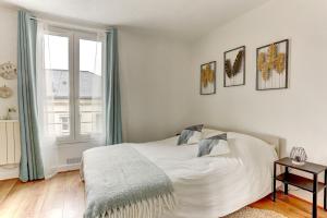 sypialnia z białym łóżkiem i oknem w obiekcie Le Dangeau - Versailles w Wersalu