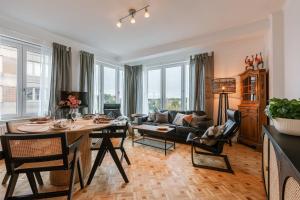 uma sala de estar com uma mesa e um sofá em Cozy warm apartment with wooden touch and parking near the beach em Knokke-Heist