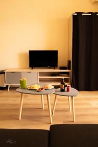 twee tafels in een woonkamer met eten erop bij Cosy Studio Coeur de l'Océan vue mer et aéroport in Saint-Denis