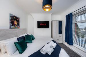 Morriston的住宿－Horeb House TV in every bedroom!，一间卧室配有带绿色和白色枕头的床