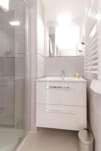 uma casa de banho branca com um lavatório e um chuveiro em SELECT'SO HOME - Résidence Le Poséidon - Mazet en Duplex pour 6 personnes - Piscine, Parking privé - Services hôteliers - POS-A em Bormes-les-Mimosas