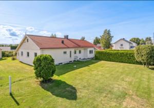 a large yard with a house and a hedge at Gardermoen House in Gardermoen