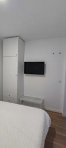 a bedroom with a bed and a tv on a wall at Calesapart2 Brisa Marina in Candelaria