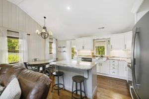 a kitchen with white cabinets and a table and chairs at Mill Stream Cottage in Pigeon Forge