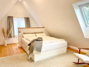 a bedroom with a white bed in a attic at Cosy Concept - nahe Hamburg in Pinneberg