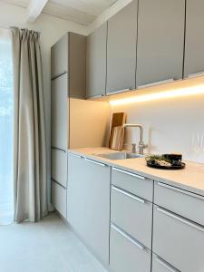 uma cozinha com armários brancos e um lavatório em Cosy Concept - nahe Hamburg em Pinneberg