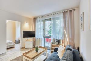 a living room with a blue couch and a large window at Apartamenty Świnoujście - Zdrojowa in Świnoujście