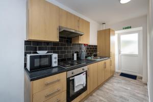 a kitchen with a microwave and a stove top oven at Neath road -Flat 3 in Swansea