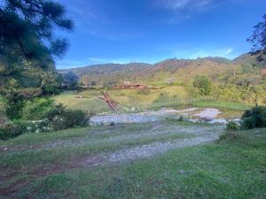 vista su una collina con una fattoria in lontananza di Tahamies Hostal - Artesanos y Turistas. a Guatapé