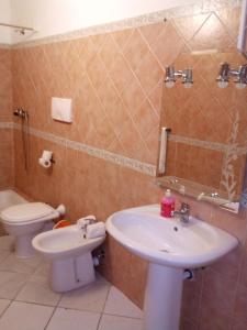 Hostels Holiday Cape Verde في سانتا ماريا: حمام مع حوض ومرحاض