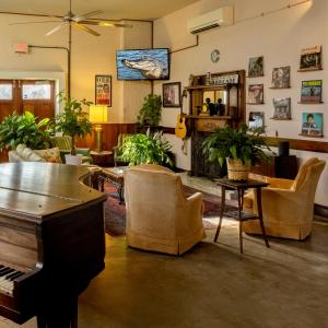 uma sala de estar com um piano e cadeiras em Inn at the Old Jail em Nova Orleans