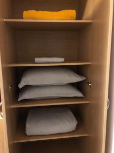 a book shelf with pillows and a yellow pillow at Adrian Home 3 rooms apartment in Ploieşti