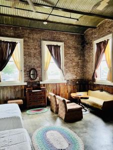 a bedroom with two beds and a table and windows at Inn at the Old Jail in New Orleans