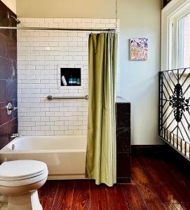 a bathroom with a toilet and a bath tub at Inn at the Old Jail in New Orleans
