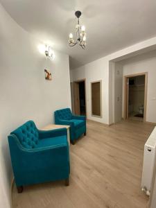 een woonkamer met twee blauwe stoelen en een tafel bij Prestige Residence in Alba Iulia