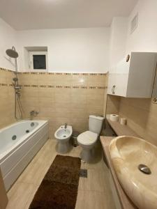 een badkamer met een toilet, een bad en een wastafel bij Prestige Residence in Alba Iulia