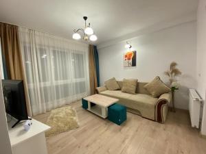 een woonkamer met een bank en een tv bij Prestige Residence in Alba Iulia