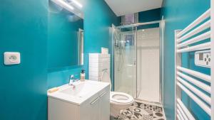 a blue bathroom with a toilet and a sink at Le Vertuose - Welc'Home in Limoges +8 photos