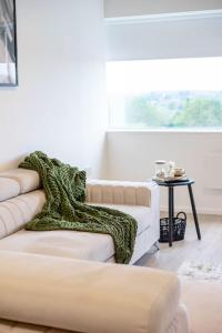 a living room with a white couch and a table at Elegant central apartment 3 in Milton Keynes
