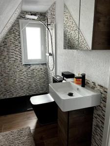 ein Bad mit einem weißen Waschbecken und einem Fenster in der Unterkunft Ferienhaus Marianne im Harz in Langelsheim