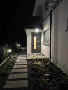 a house with lights on the side of it at night at Apartament Magnoliowy in Owińska