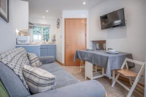 a living room with a couch and a table at Tor Bay Cottage - 1 Bedroom - Parkmill in Parkmill